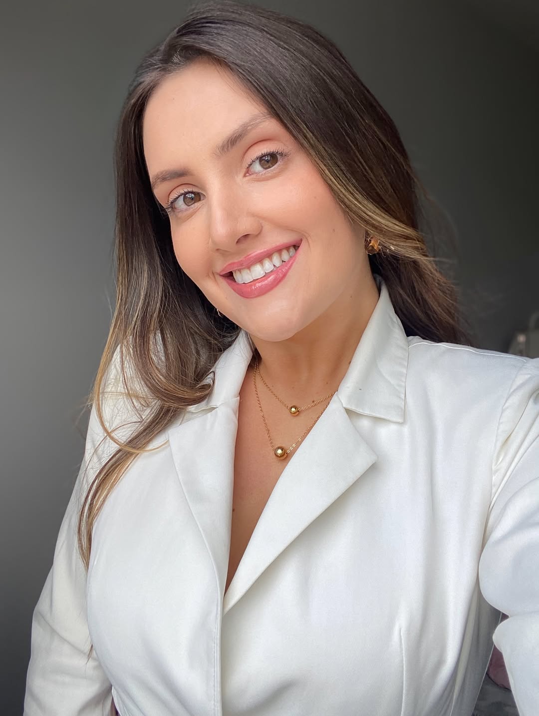 Dra. Maria Eduarda Telles sorrindo, com jaleco branco
